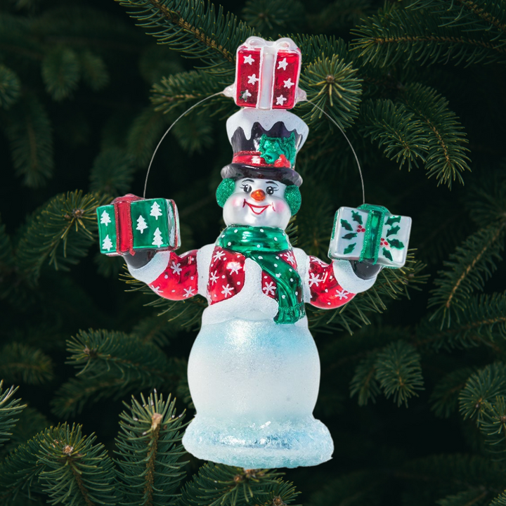 Ornament Description - Gift Juggling Juggler: Mr. Snowman is used to being extra busy during the holiday season-- good thing he's an expert juggler! He's dressed in his festive finest to deliver gifts and spread Christmas cheer all over town.