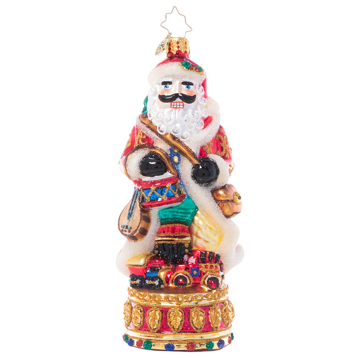 Front - Ornament Description - Stately Conductor: Donning his finest fur-trimmed robe, this festive nutcracker is loaded up with everything he needs to celebrate the season. Bearing gifts, music, and even a miniature tree on his back, he's definitely "nuts" about Christmas!