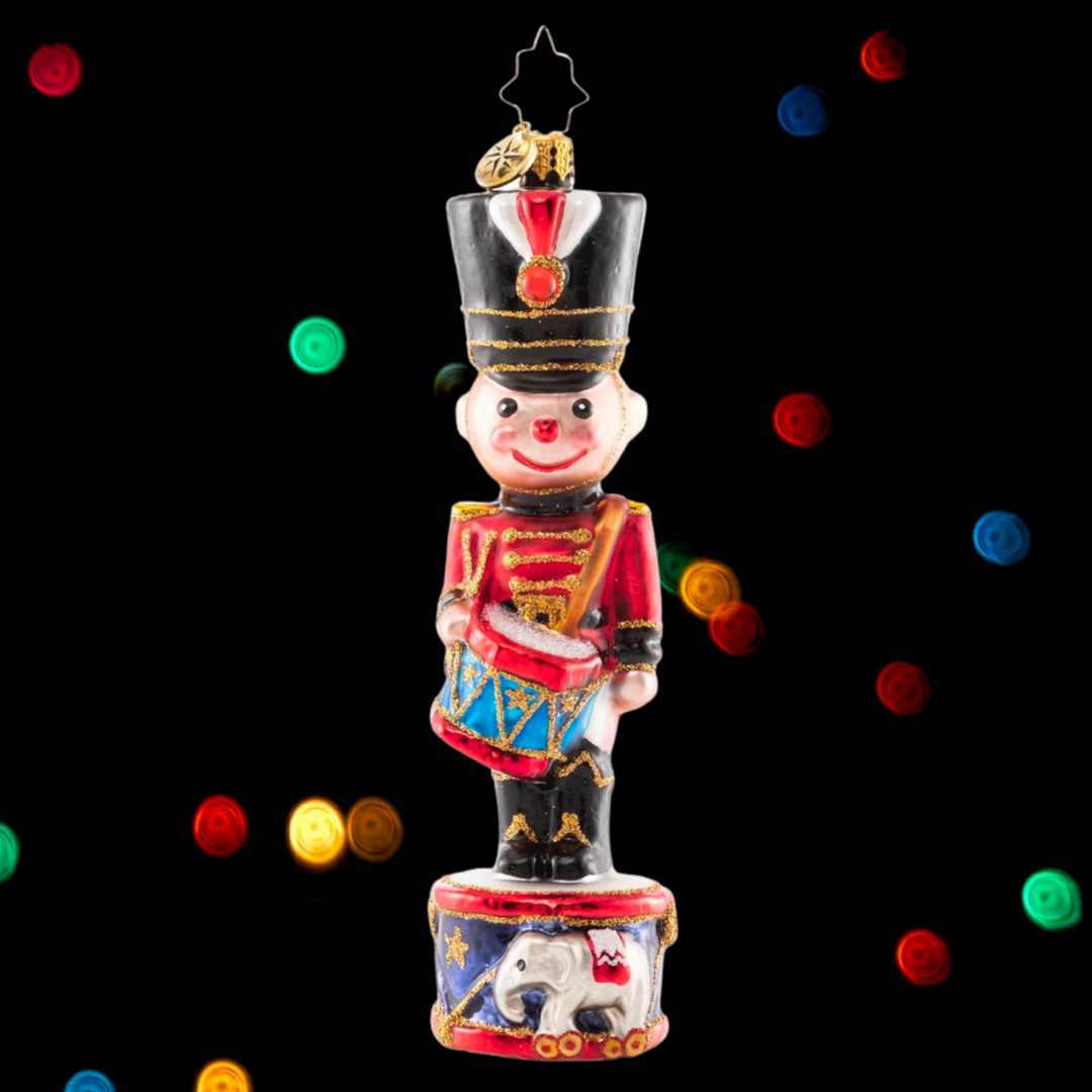 Ornament Description - Cheerful Toy Solider: A-ten-hut! Dressed in a holiday red coat and shiny black boots, this smiling soldier grins from his post atop a Christmas drum.