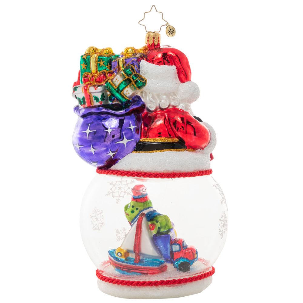 Back - Ornament Description - Santa's Magic Snow Globe: It's a wonderful time of the year for Santa Claus, who's looking even more jolly than usual! With his sack of surprises slung over his shoulder, he smiles over a pile of Christmas toys inside a swirling snow globe.