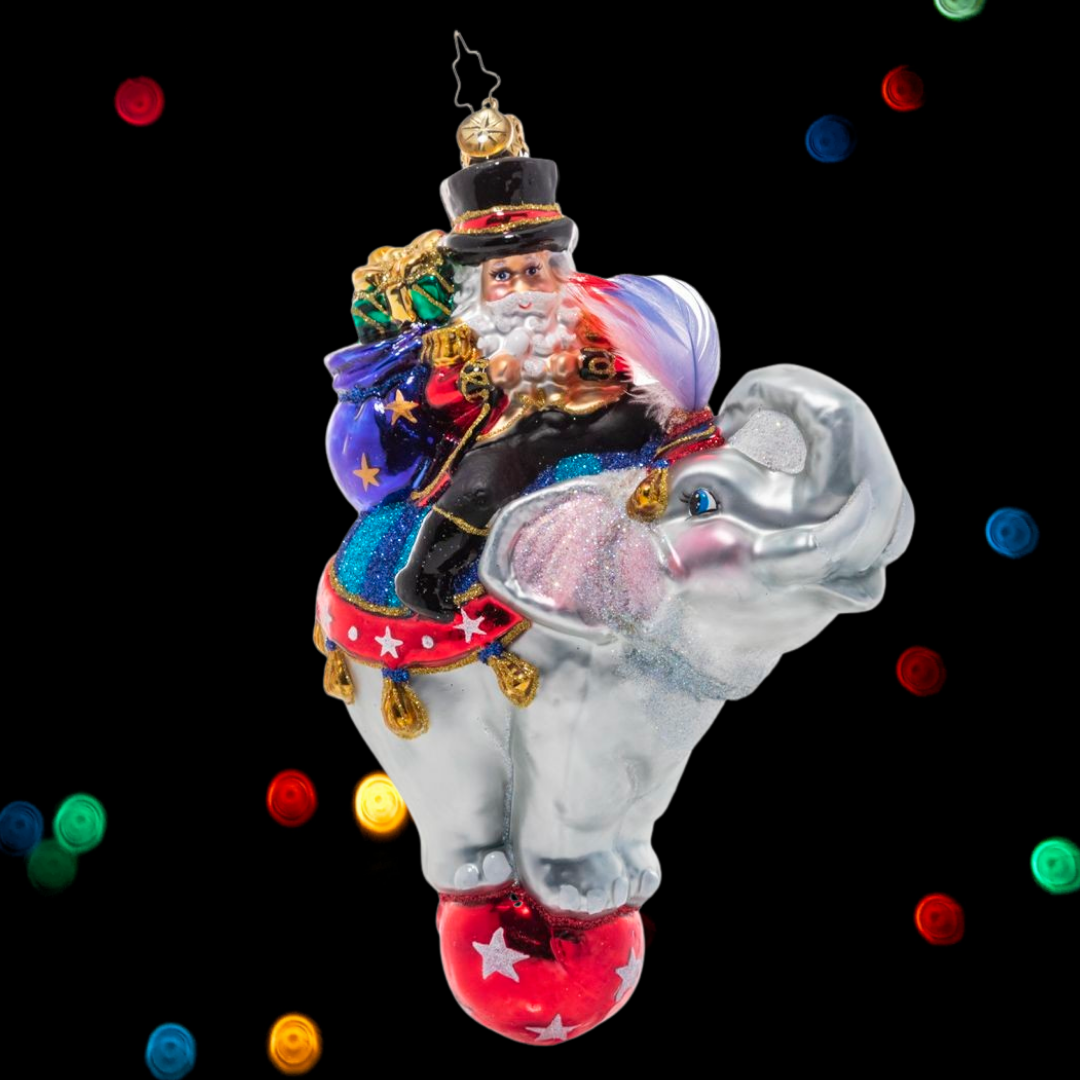 Ornament Description - Ringmaster Claus: Step right up! Santa's no stranger to running the show so it only makes sense that he'd be master of his own circus! He smiles from atop a talented elephant performer on the night of the big show.