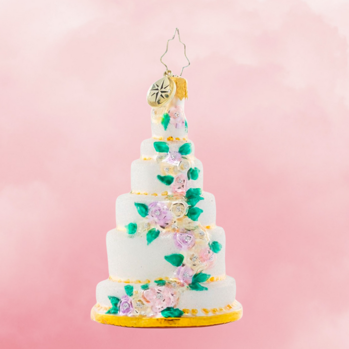 Ornament Description - Six-Tier Celebration Gem: Be the envy of every baker with this towering tiered cake ornament. Decorated with a cascade of colorful spring blooms, it's lucky that it's the kind of cake that will last year after year because this piece is almost too beautiful to eat!