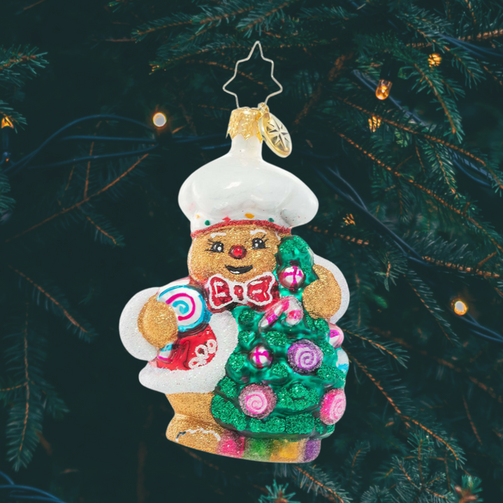 Ornament Description - Edible Evergreen Dream Gem: This smiling gingerbread baker has whipped up a batch of his specialty – Christmas candy ornaments for his tree! He can't wait to celebrate his favorite season with all his gingerbread friends!