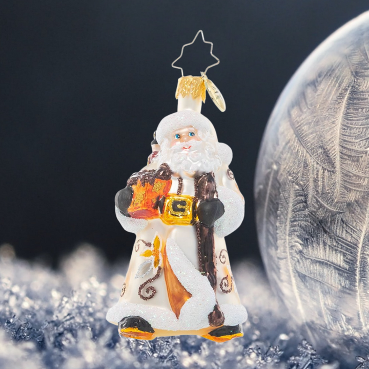 Ornament Description - Bountiful Basket Traveler Gem: Dressed in wintry white and carrying a basket of sundries, Santa looks ready for a long trek. It's a snowy one out there, but luckily he's an expert North Pole navigator!