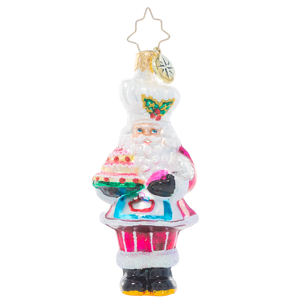 Ornament Description - Santa's Tower of Flour Gem: When Santa bakes, you know it's made with love – and a little Christmas magic! He's showing off his latest sweet creation from the North Pole bakery.