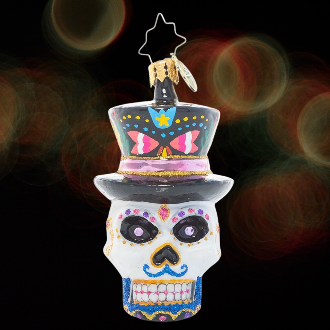 Ornament Description - One Dapper Calavera Gem: This sugar skull ornament is truly head-turning! With a top hat, bold colors and intricate detailing, this calavera looks ready for his big night.