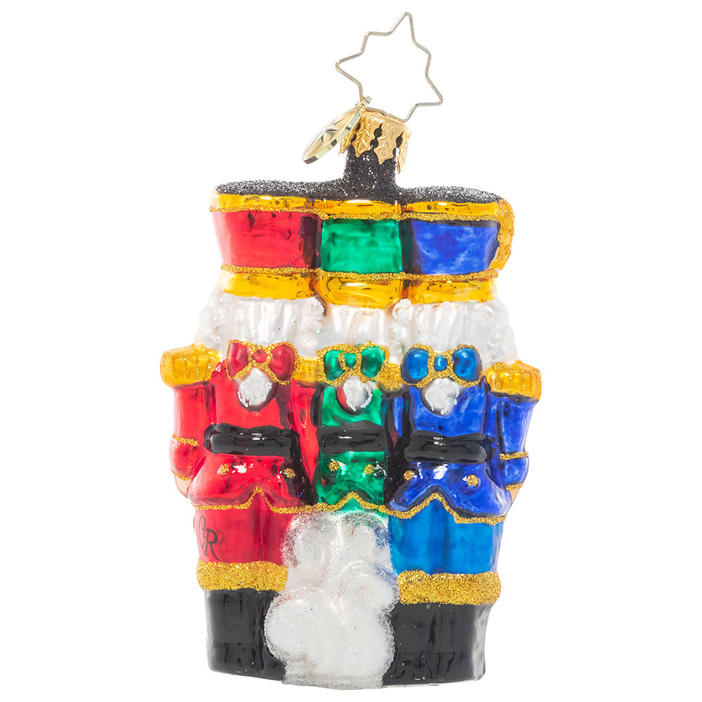 Back - Ornament Description - The Nut-Cracking Pack Gem: Thrice as nice! A trio of nutcracker soldiers stand together, grinning in royal uniforms of bright Christmas jewel tones.