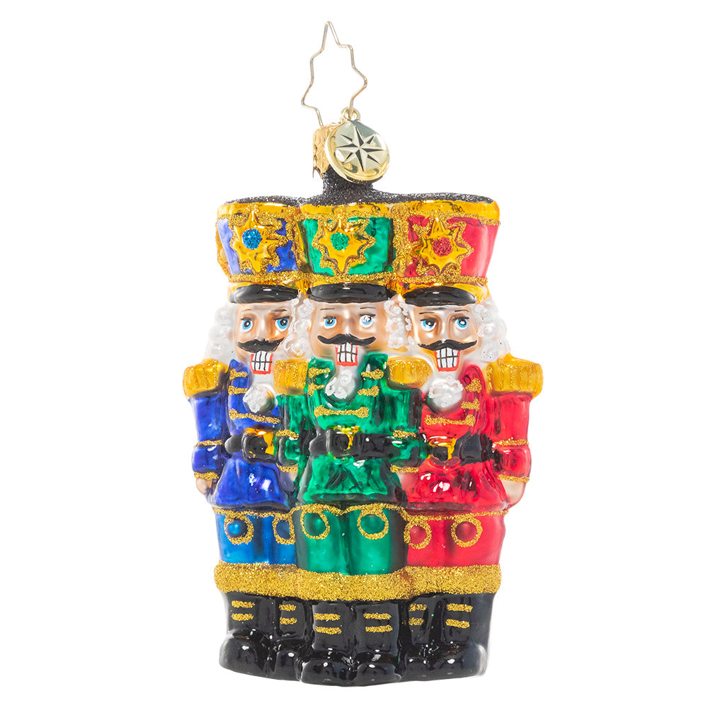 Front - Ornament Description - The Nut-Cracking Pack Gem: Thrice as nice! A trio of nutcracker soldiers stand together, grinning in royal uniforms of bright Christmas jewel tones.