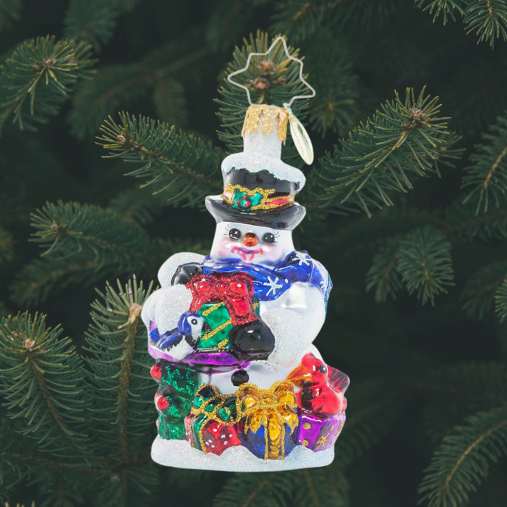 Ornament Description - A Little Bird Told Me Gem: This tiny snowman has some extra help with his Christmas gift wrapping this year! He's enlisted the help of two bitty birdie visitors as he prepares presents for all his friends.