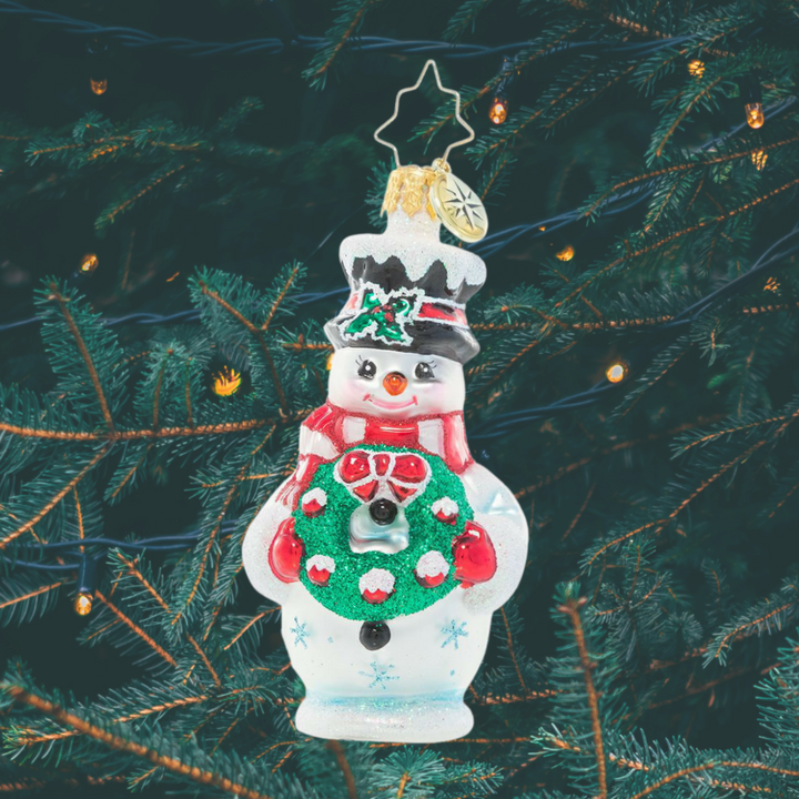 Ornament Description - Darling Christmas Decorator Gem: This frosty snowman has been waiting all year long to deck the halls! He's fashioned his very own wreath and is excited to help his friends turn the town into a festive winter wonderland.