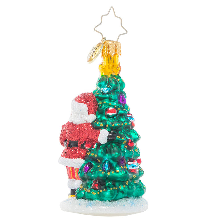 Back - Ornament Description - Two Talented Tree Trimmers: Time to deck the halls! Enlisting the help of his reindeer companion, Santa trims the North Pole Christmas tree in his favorite heirloom ornaments.