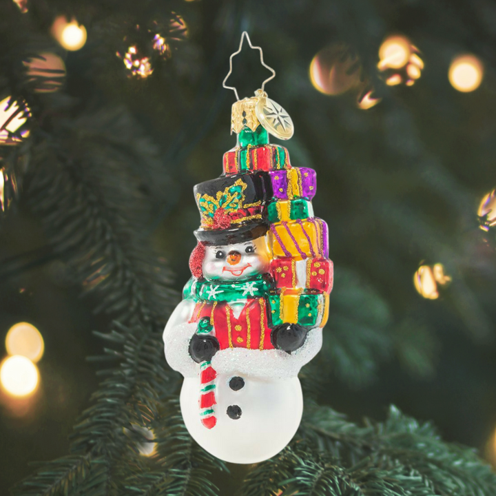 Ornament Description - Savvy Shopper Gem: This snowman takes Christmas shopping very seriously! He's spent his day finding just the right gifts for everyone on his list – time to return home to put them under the tree!