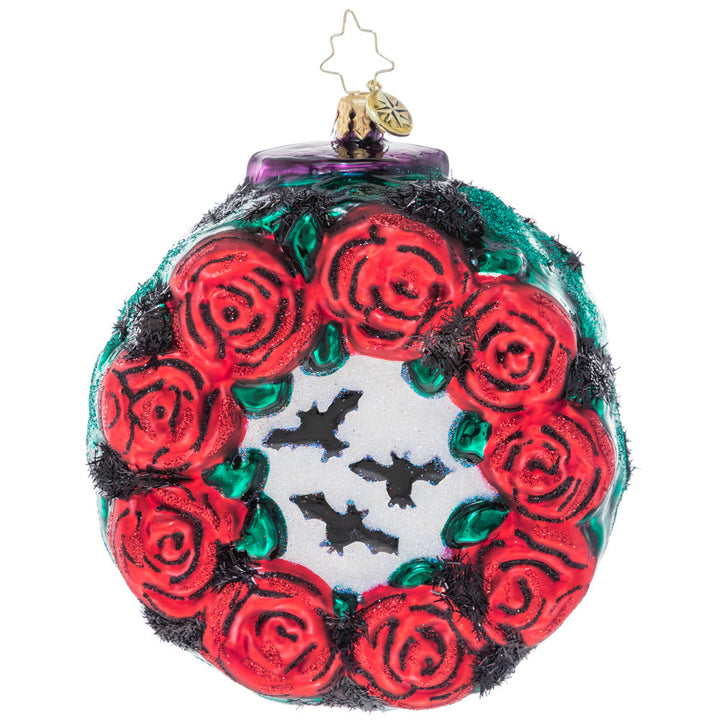 Back - Ornament Description - Spooky Skull Wreath: Celebrate spooky season with this gothic-inspired calavera wreath. A ring of blood-red roses encircles a trio of black bats and a grimacing sugar skull – all things that make Halloween so frightfully fun!