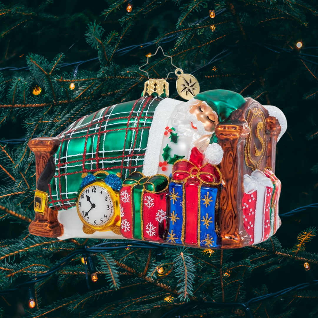 Ornament Description - Catching Z's Mr. Claus: The holiday season is a busy one, and no one knows that better than Santa Claus! After his last Christmas Eve delivery is complete, he settles in for a well-deserved long winter's nap.