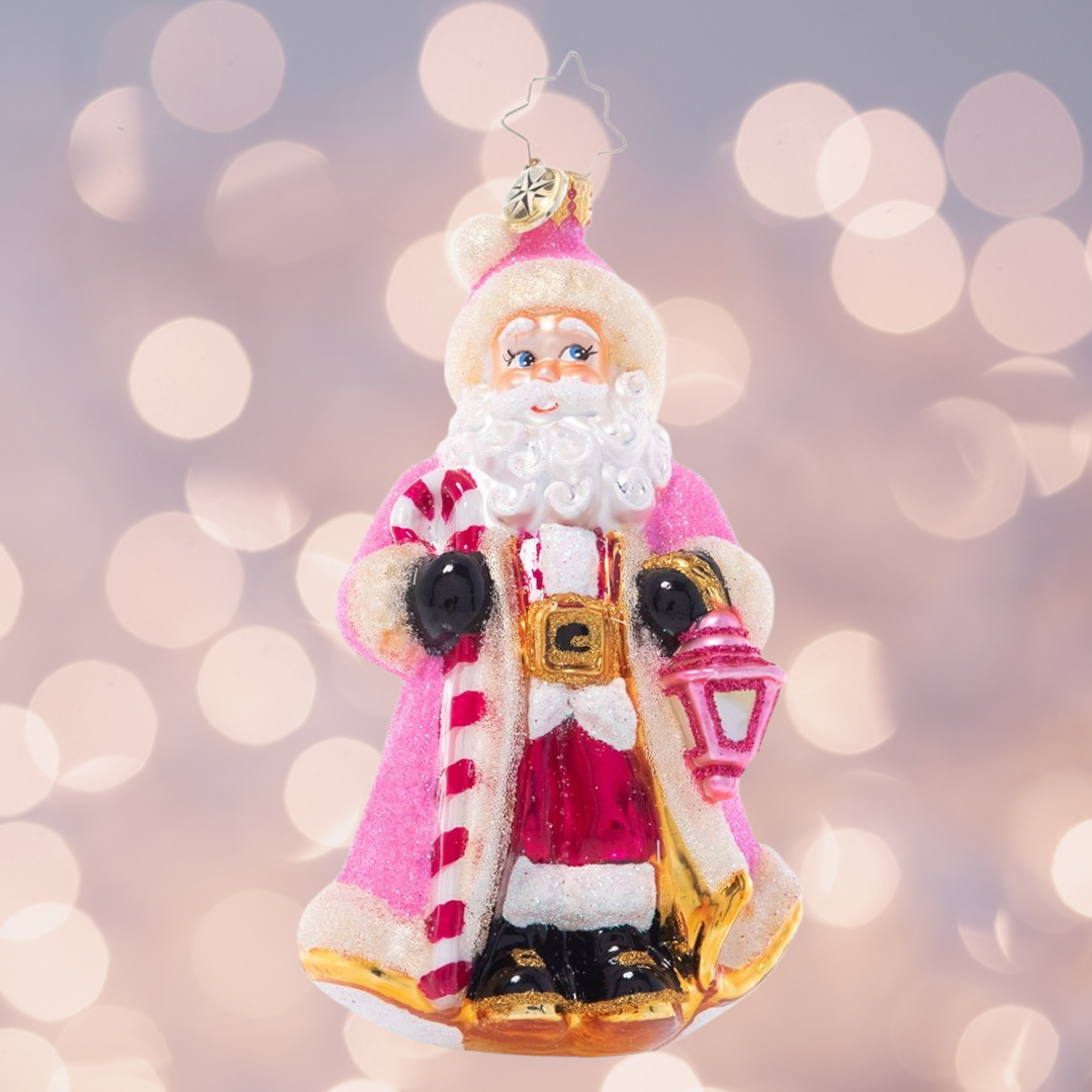 Ornament Description - Donned in Pink: Cloaked in sparkling pink from head to toe, this Santa looks as sweet as sugar as he lights the way through a snowy winter's night.