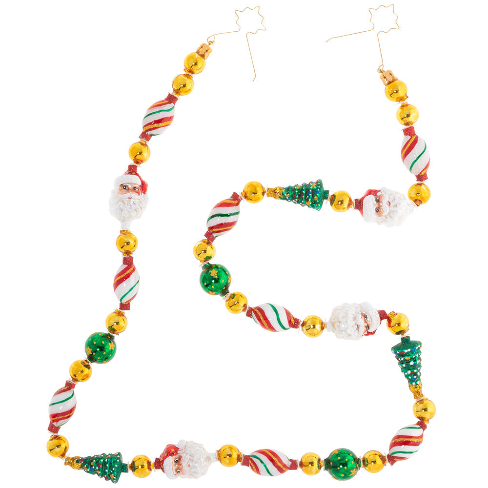 Garland/Trim Description - Garland Grandeur: Time to trim the tree! This traditional Christmas garland is a classic holiday combination of lush green trees, peppermint Christmas candy, and Santa's smiling face together with shining gold & green beads.