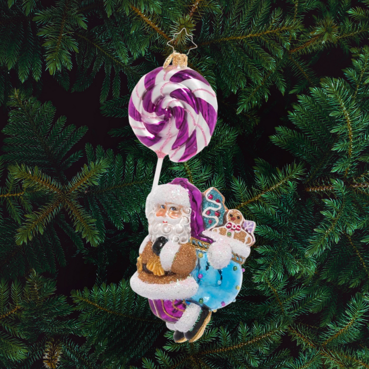 Ornament Description - Lolli Jolly Christmas: May your holiday be extra sweet this year! Santa dangles from a twirly, swirly purple lollipop on his way to deliver a sack full of goodies.