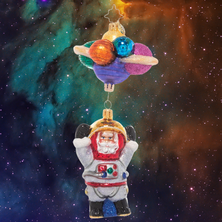 Ornament Description - Santa in Space: 3…2…1…blast off! Santa is exploring the final frontier of space, bravely going where no elf has gone before! He grins from inside his space suit, dangling from a cluster of colorful planets.