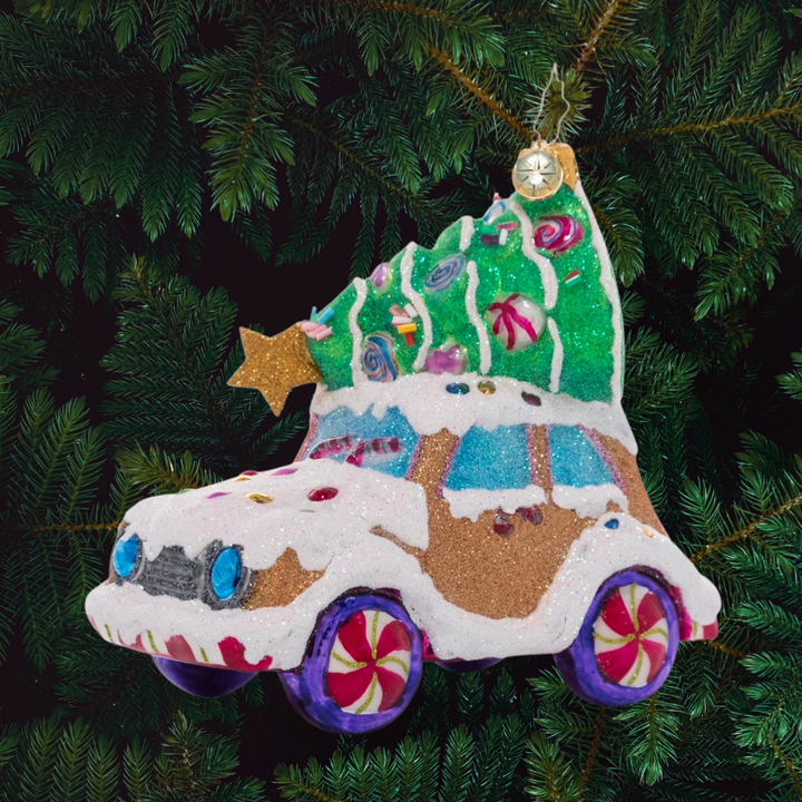 Ornament Description - Candy Tree Delivery: Over the river and through the woods…someone has driven this cookie car far and wide to find the perfect candy Christmas tree! It looks like they picked one that will be just right to brighten up their cozy gingerbread house.