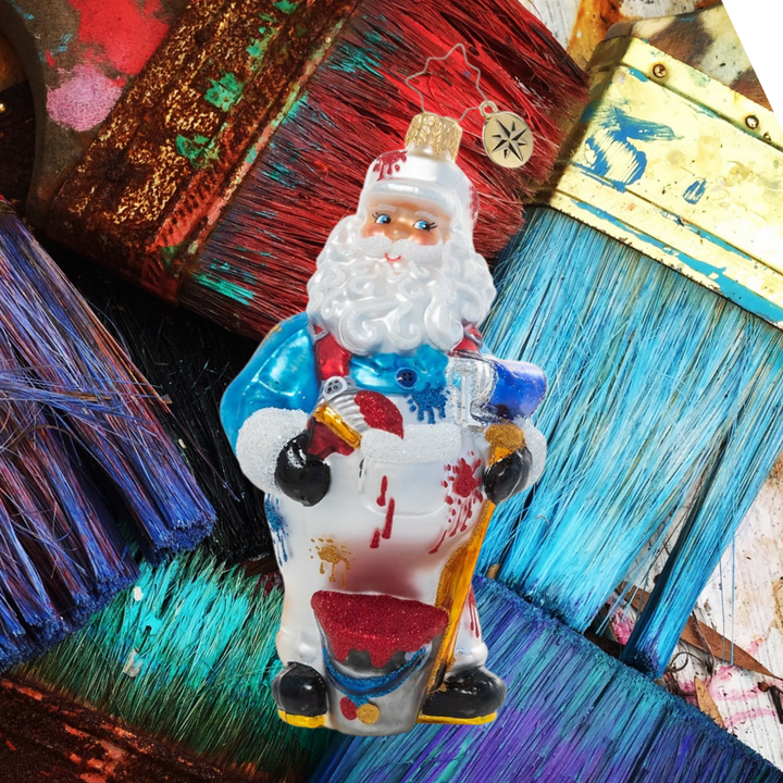 Ornament Description - Wet Paint Santa: Uh-oh! Santa's been hard at work on some DIY painting and has made quite a mess of his snow-white overalls. Maybe this is one job best left to the elves, buddy!
