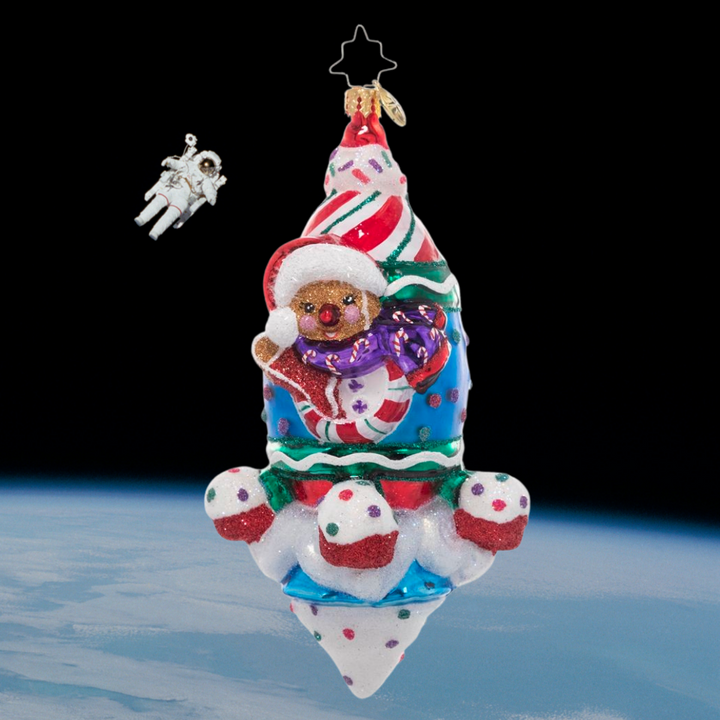 Ornament Description - Tasts of Space: A super sweet rocket ship blasts into space piloted by a smiling gingerbread man. Good thing he's bundled up – it gets cold up there!