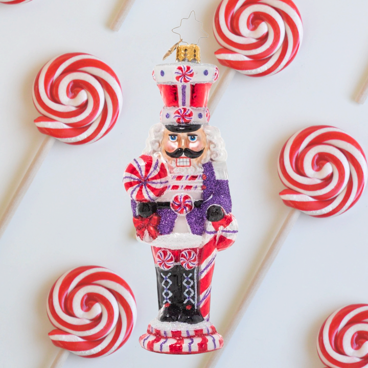 Ornament Description - Candy Cane Cracker: How sweet it is! This peppy candy-cane themed nutcracker is ready to celebrate the holiday season in swirling red and white.