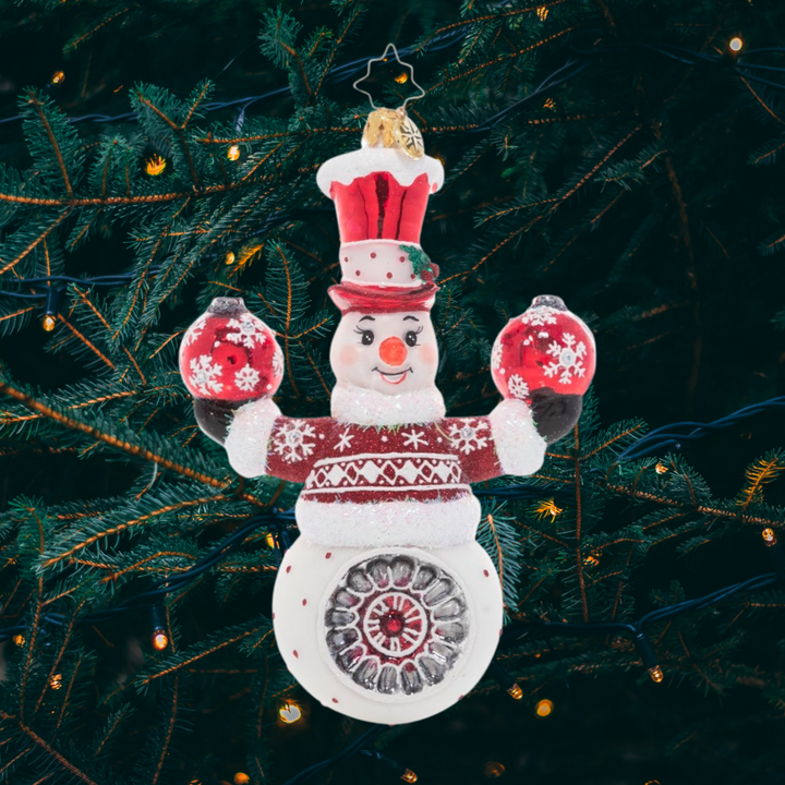 Ornament Description - Cheery Snowman Juggler: This acrobatic snowman is ready to demonstrate his tricks and spread good cheer by juggling two festive Christmas ornaments.
