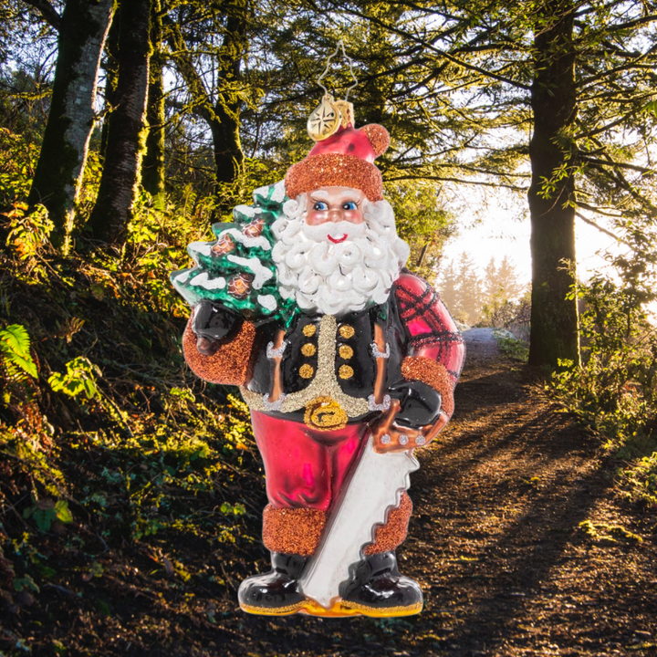 Ornament Description - Winter Woodsman Santa: Santa has spent all day trekking through the snowy North Pole woods in search of the perfect Christmas tree for the Claus household…and he's finally found the one! He poses proudly with his selection slung over his shoulder. Now it's time to decorate!