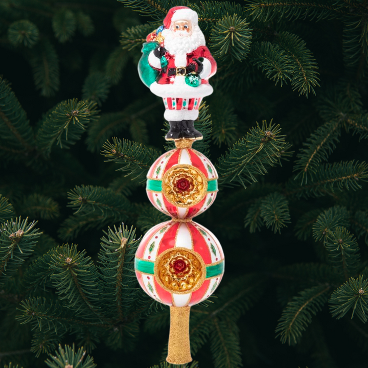 Finial Description - Christmas Classics Finial: Top the tree with good cheer with this Santa finial inspired by classic Christmas tradition. Standing tall above two golden starbursts, Santa is the perfect finishing touch to your tree!