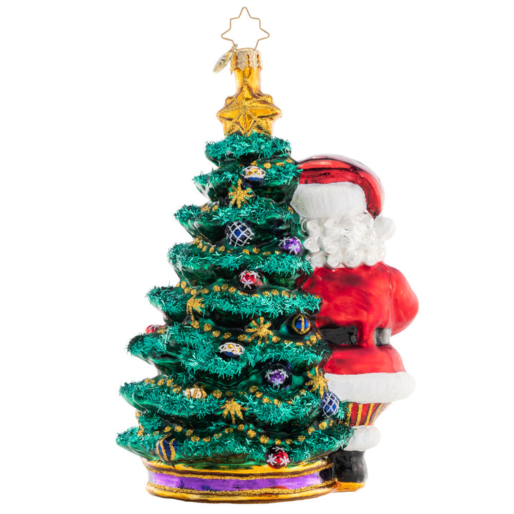 Back - Ornament Description - Deck the Halls Santa: Santa is ready to show off his extensive ornament collection as he trims his Christmas tree with beautiful glass baubles.