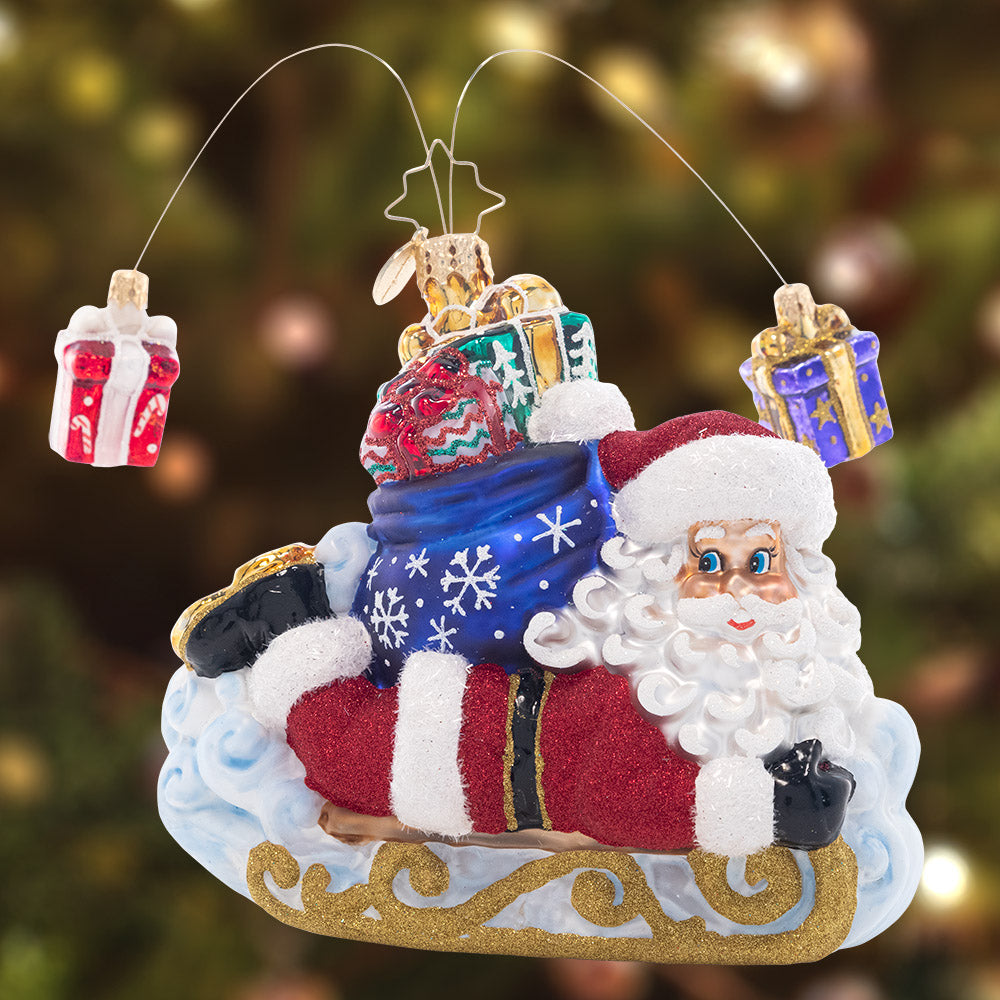 Ornament Description - Snow Sliding Santa: Slipping and sliding through the snow, Santa is having fun while making a sled-powered Christmas gift delivery!