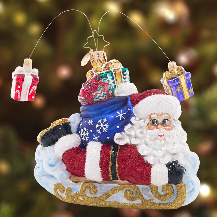 Ornament Description - Snow Sliding Santa: Slipping and sliding through the snow, Santa is having fun while making a sled-powered Christmas gift delivery!