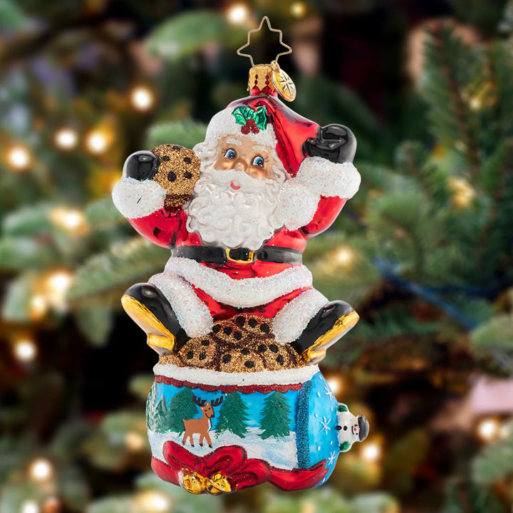 Ornament Description - Santa's Snack Break: Delivering presents all around the world is hard work! Santa is taking a much-needed break atop a cookie jar decorated with a wintertime scene.