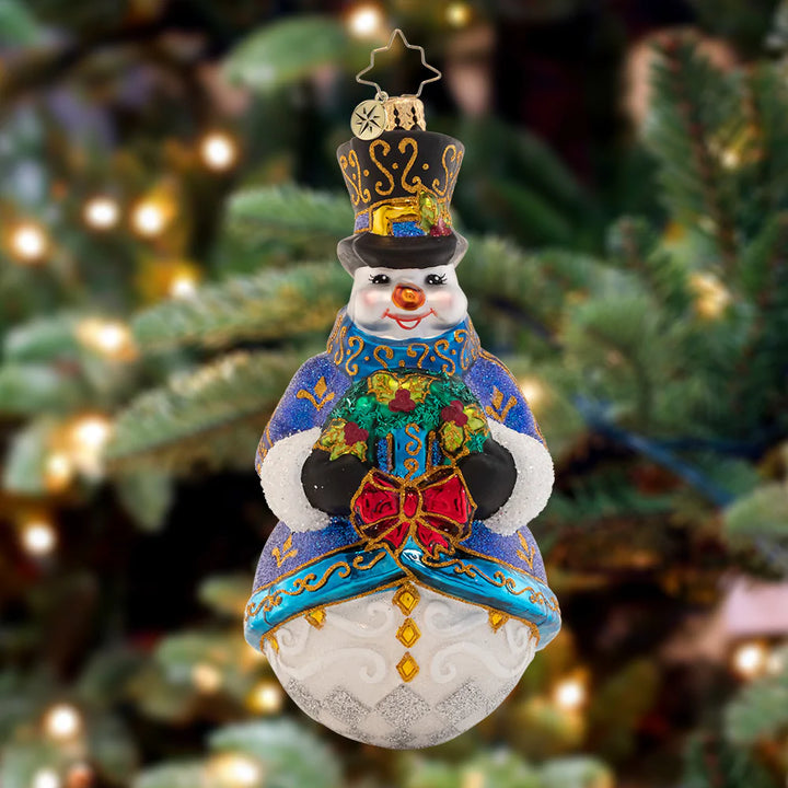 Ornament Description - Winter's Frost Snowman: What a snazzy snowman! With an ornately-glittered winter coat and top hat, this little guy is presenting a glorious gift to place under the tree.