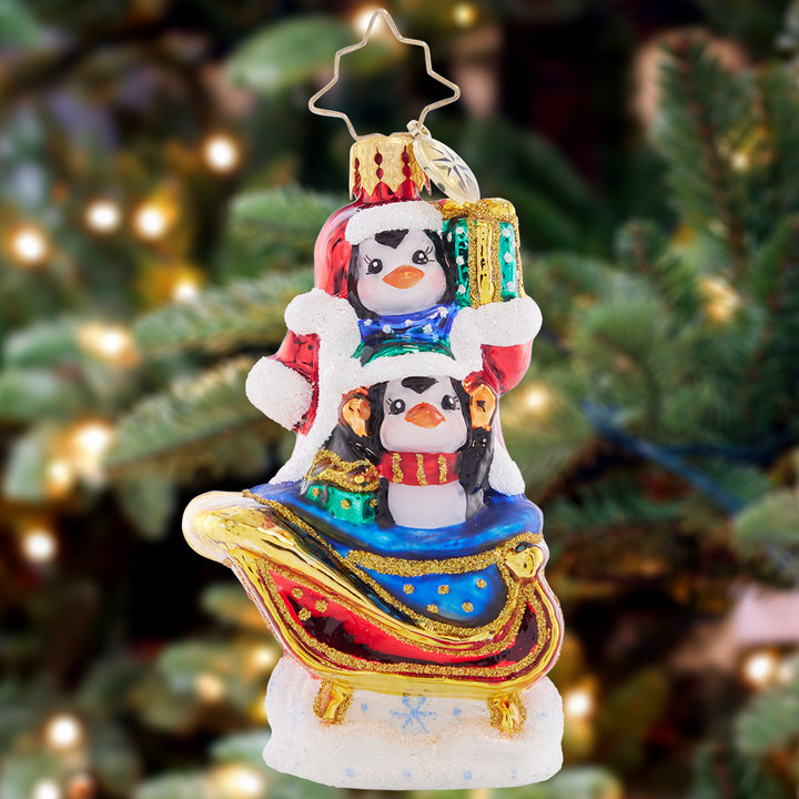 Ornament Description - Silliest Sleight Ride Gem: This pair of playful penguins are getting up to some merry-mischief, disguising themselves as Santa Claus in his trademark red coat! Strap in to the sleigh for a silly ride through the snow.