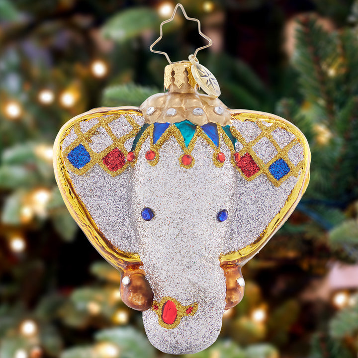 Ornament Description - Opulent Elephant Gem: Adorned with a bejeweled headdress and gilded in gold, this opulent elephant piece will bestow wisdom and good fortune upon your home this holiday season.