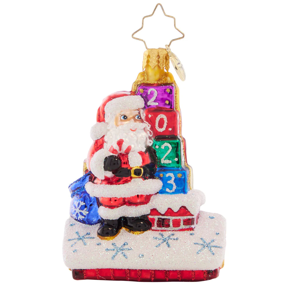 Ornament Description - Another Wonderful Year Gem: Cheers to another wonderful year! This little ornament is a great way to celebrate 2023, showing Santa up on the rooftop making his Christmas Eve delivery.