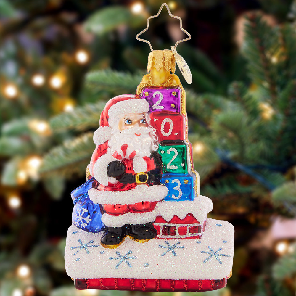Ornament Description - Another Wonderful Year Gem: Cheers to another wonderful year! This little ornament is a great way to celebrate 2023, showing Santa up on the rooftop making his Christmas Eve delivery.