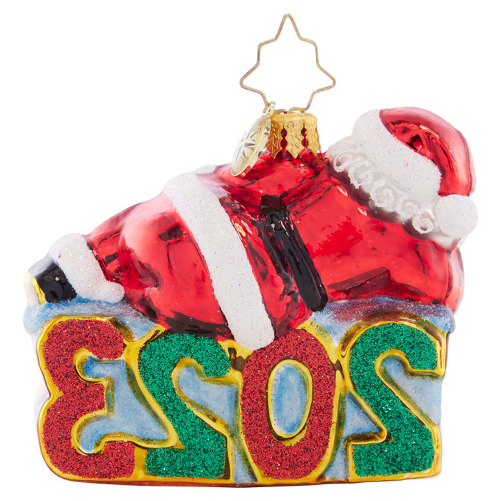 Back - Ornament Description - Shining Bright Santa 2023 Gem: Santa is enjoying a wonderful year, now that all of his Christmas preparations are finished. He's kicking back and relaxing atop this dated Little Gem.
