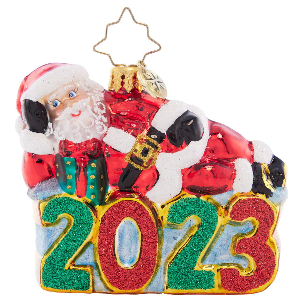 Front - Ornament Description - Shining Bright Santa 2023 Gem: Santa is enjoying a wonderful year, now that all of his Christmas preparations are finished. He's kicking back and relaxing atop this dated Little Gem.