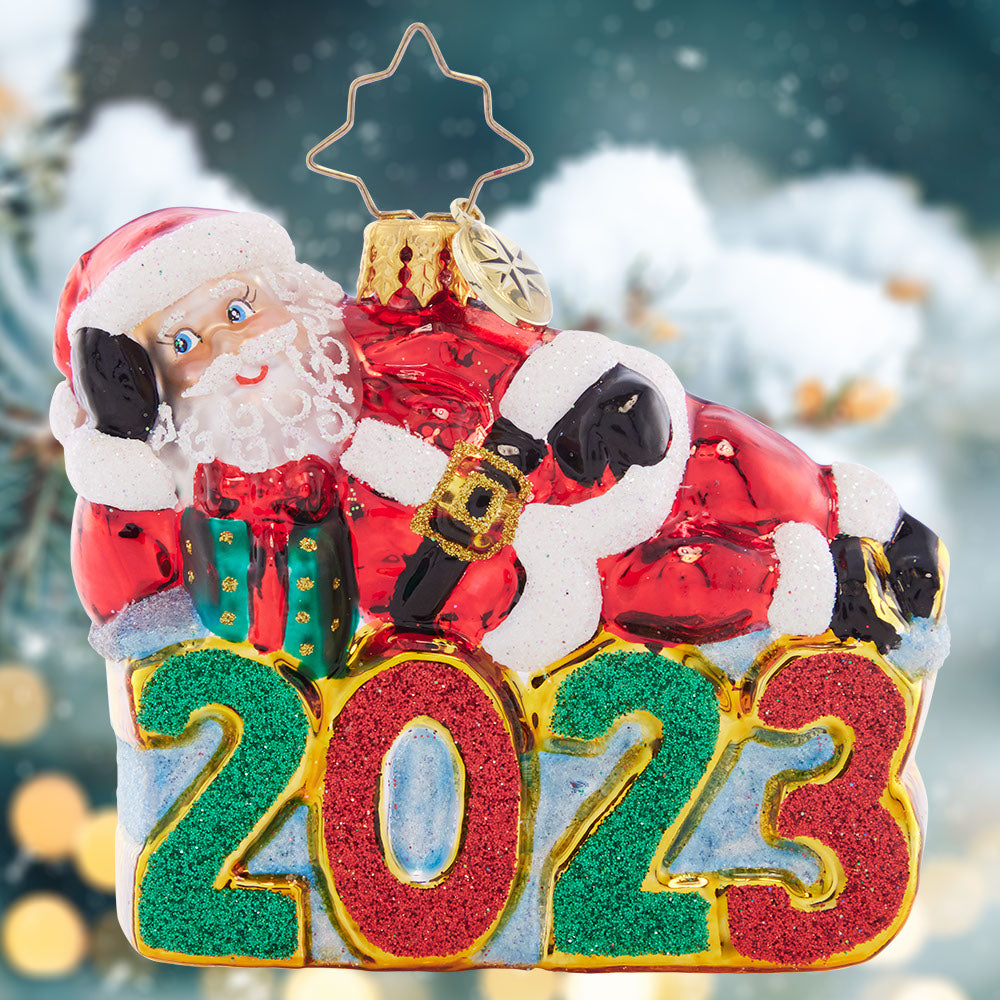 Ornament Description - Shining Bright Santa 2023 Gem: Santa is enjoying a wonderful year, now that all of his Christmas preparations are finished. He's kicking back and relaxing atop this dated Little Gem.