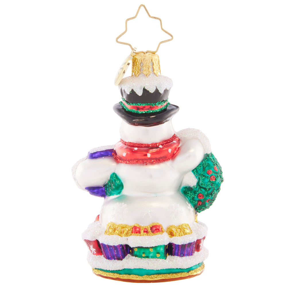 Back - Ornament Description - Holly Jolly Snowman 2023 Gem: This jolly snowman is joyfully looking ahead to the new year. Bearing a Christmas wreath and a gilded gift, he's bringing good tidings all holiday season long.