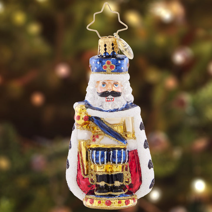 Ornament Description - Nutcracking Royalty Gem: All hail this regal nutcracker! This little gem spares none of the pomp and circumstance, presenting a regal protector dressed in royal blue and a fur-lined cape.