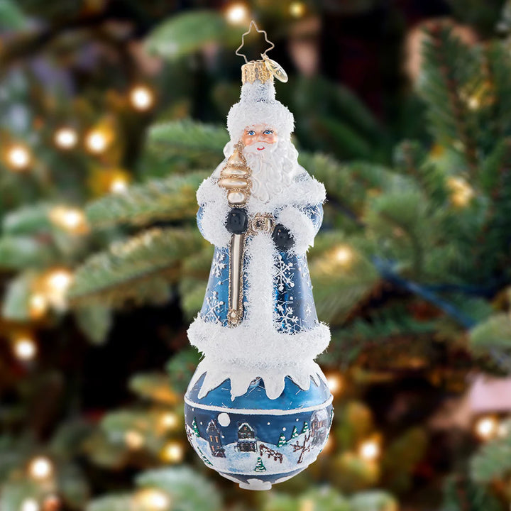 Ornament Description - Snowy Serenity Santa: This snowflake-covered Santa stands upon a serene scene round, showcasing a beautiful silent night. This piece is an intricate and charming addition to any tree!