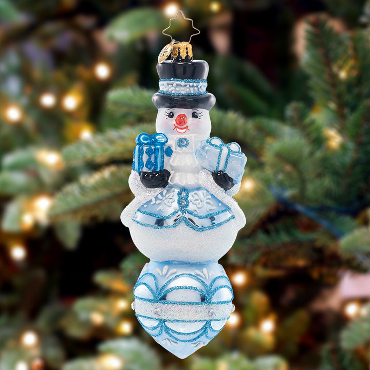 Ornament Description - Frosty Snow Fellow: Looking extra frosty and fresh, this festive snow-fella is perched upon a radiant reflector drop.