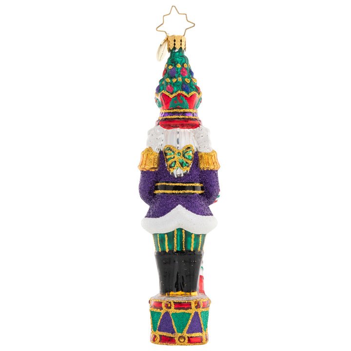 Back - Ornament Description - Christmas Commander Nutcracker: Complete with a Christmas tree crown, this nutcracker is truly a commanding presence! He's ready to make this holiday the best one yet with a candy cane staff and plenty of gifts..