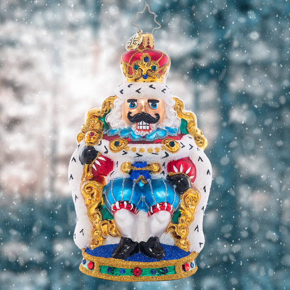 Ornament Description - At Home on the Throne: The nutcracker king is keeping court at the candy castle, sitting comfortably in a gilded throne. Add a regal touch to your tree with this stunning piece!
