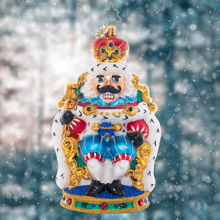 Ornament Description - At Home on the Throne: The nutcracker king is keeping court at the candy castle, sitting comfortably in a gilded throne. Add a regal touch to your tree with this stunning piece!