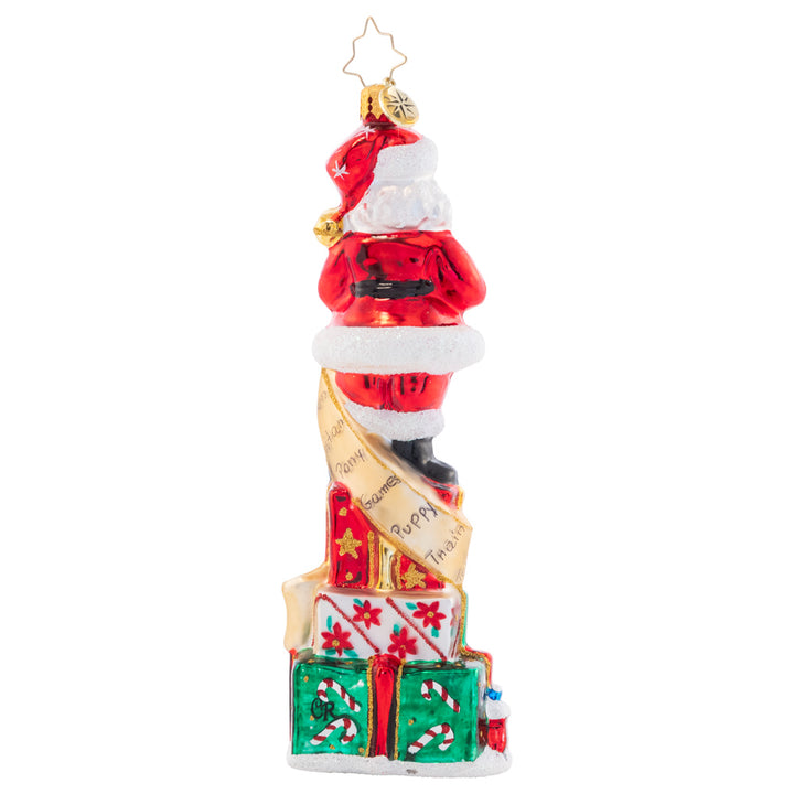 Back - Ornament Description - Stacked Up Santa: Quite a lengthy wish list this child sent in! Much time and consideration was spent filling it in. Santa has to stand on many presents stacked to check off each gift as they're carefully packed.
