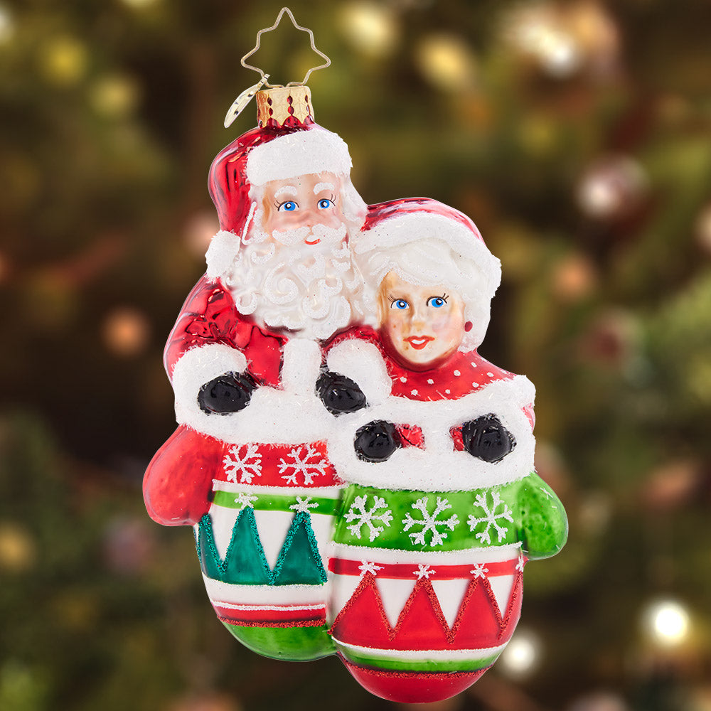 Ornament Description - Christmas Couple: Mr. and Mrs. Claus are sure looking smitten, all cozy warm in a pair of mittens. With classic Christmas colors and detailed decoration, this wonderful ornament elicits elation.